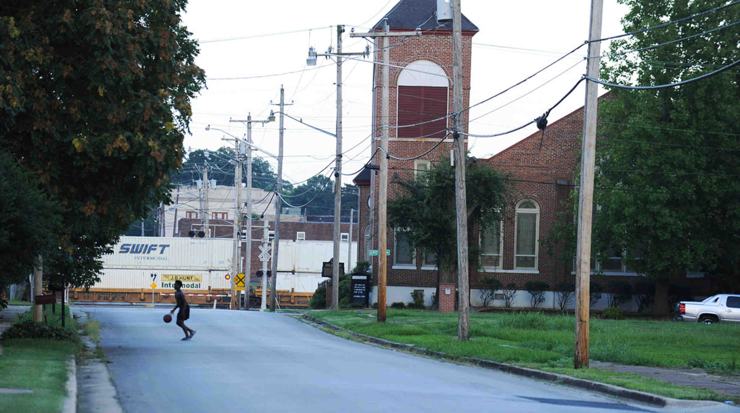 street in decatur, alabama with kid playing basketball in the distance