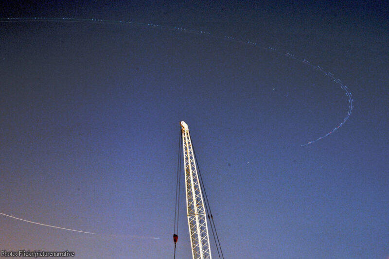 Image of plane circling in sky over radio tower