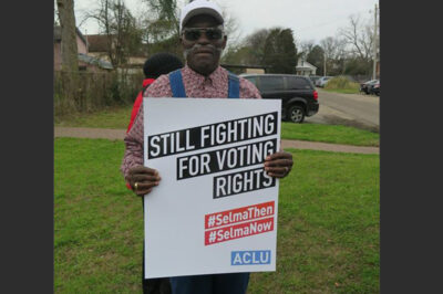 Activist at Selma holding sign: Still Fighting for Voting Rights #SelmaThen #SelmaNow