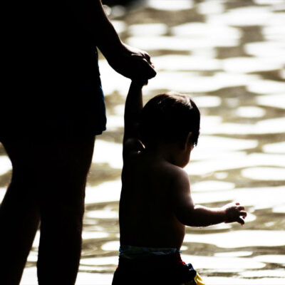 Parent holding hands with her child