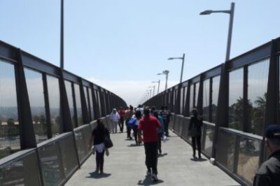 People walking over a bridge.