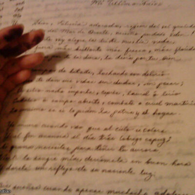 A reader's hand on a parchment letter