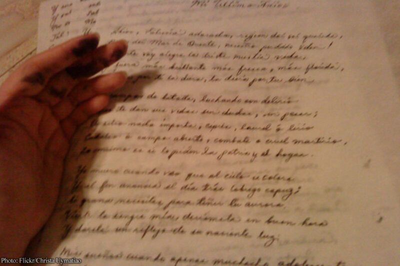 A reader's hand on a parchment letter