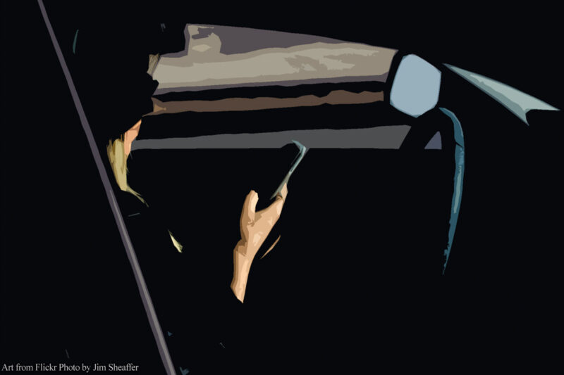Silhouette of woman holding phone behind the wheel