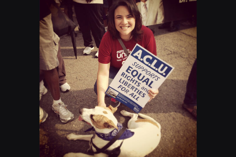 Rana Elmir and her pit bull, Olivia, at a rally with an ϰſ sign