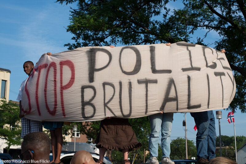 Protesters holding "Stop Police Brutality" sign