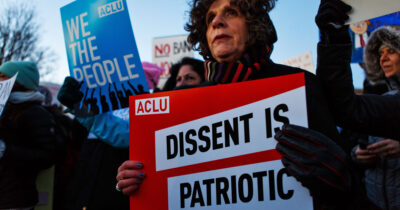 Protester holding "Dissent is Patriotic" Sign