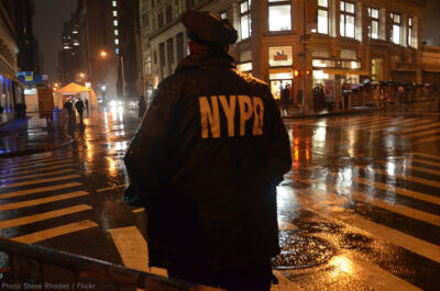 NYPD Officer standing on corner at night
