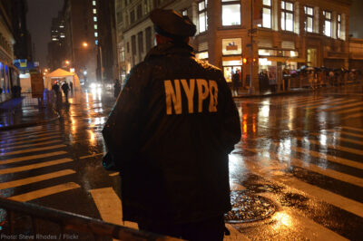 NYPD Officer standing on corner at night