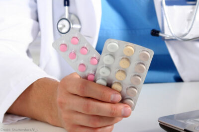 Pharmacist holding pack of birth control pills