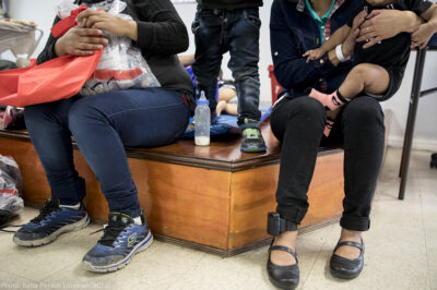 Immigrant women and children at a holding center with ankle monitors