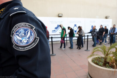 CBP Officer standing next to immigration line