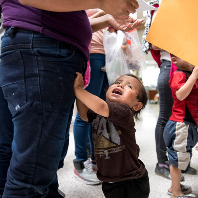 Child holding onto parent's leg