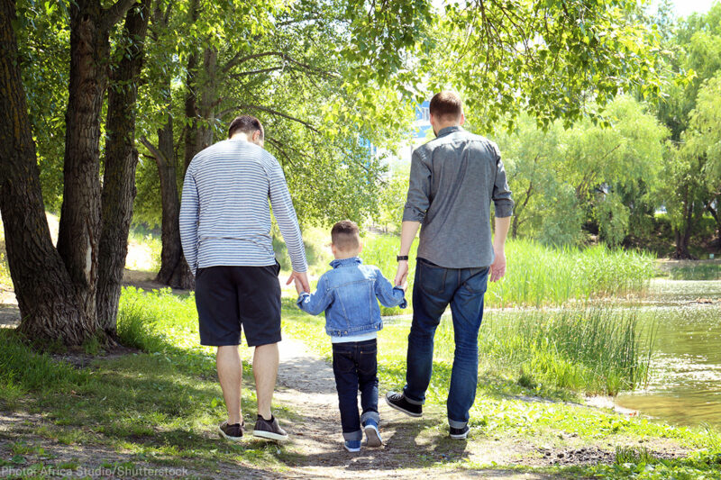 Two men walking with their child