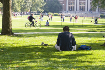 Student reading on the campus lawn