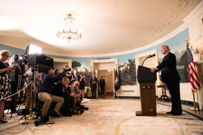 President Trump stands at a podium in front of reporters