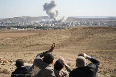 People watching a desert airstrike from a distance