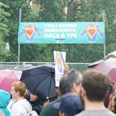 "I will defend immigrants, DACA, and TPS" sign at a rally