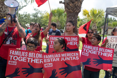 Demonstrators carrying signs with the text "Families Belong Together"