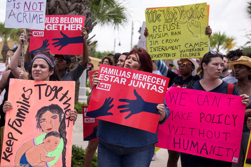 Demonstrators carrying signs urging keeping immigrant families together