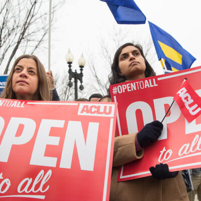 Demonstrators holding signs with the message 'Open to All"
