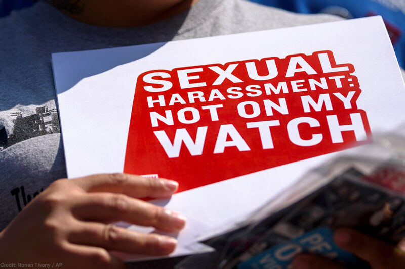 Protester holding sign stating "Sexual Harassment: Not on my Watch"