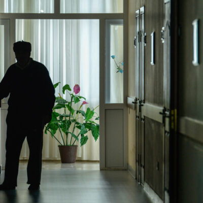 A resident walks down the darkened hall of a nursing home.