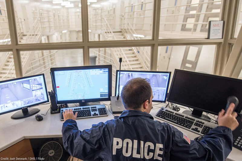 Police officer viewing multiple monitors