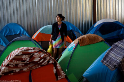 A woman from Guatemala stands surrounded by tents, in a shelter of mostly Mexican and Central American migrants waiting in the midst of the asylum application process. This comes on the heels of an unprecedented change in the US asylum process, known as the "Return to Mexico" program.