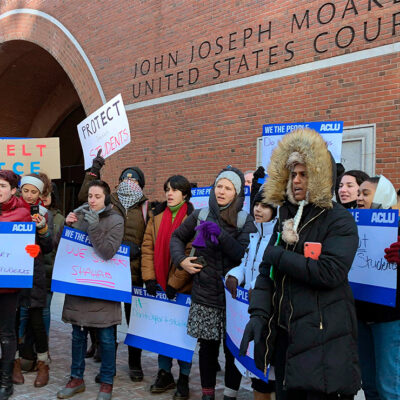 Protesters stand outside the federal courthouse where a hearing was scheduled for Northeastern University student Shahab Dehghani