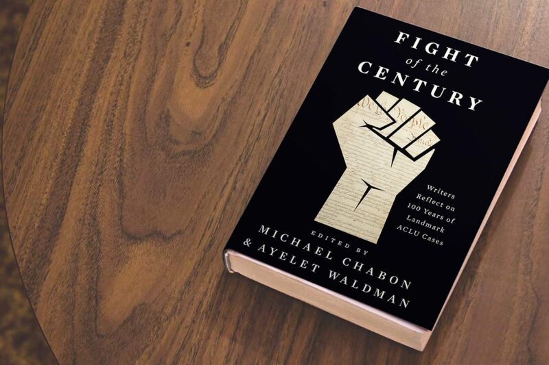 A black book titled "Fight of the Century" edited by Ayelet Waldman and Michael Chabon, lies on a wooden table