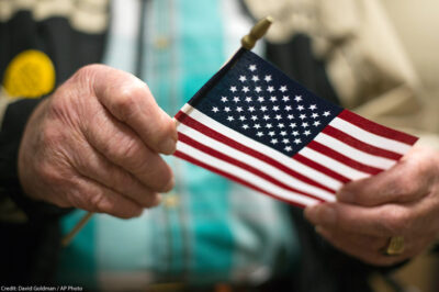 A man holding the American flag after a naturalization ceremony.