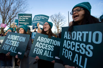 Abortion rights demonstrators hold "abortion access for all" signs at rally outside of the U.S. Supreme Court.