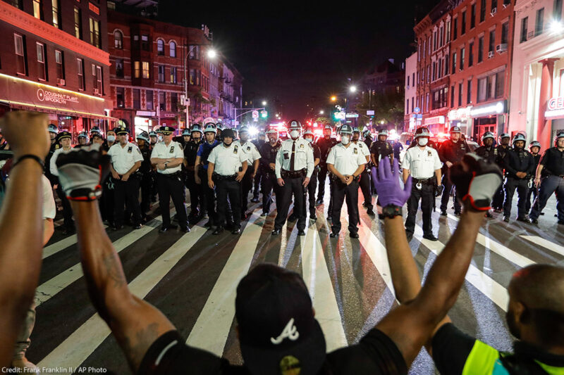 Protesters take a knee on Flatbush Avenue in front of New York City police officers during a solidarity rally for George Floyd