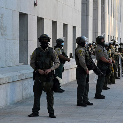 Police force stands guard in riot gear in front of Hall of Justice in Los Angeles.