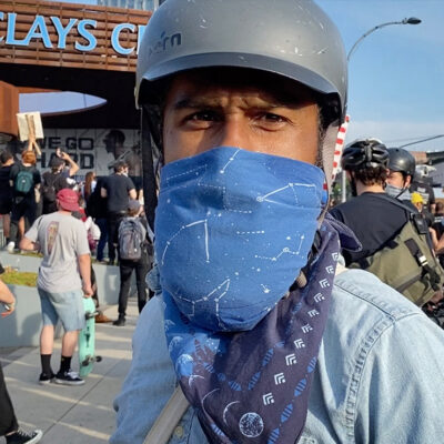 A protester wearing a bandana over their mouth in front of Brooklyn's Barclays Center.