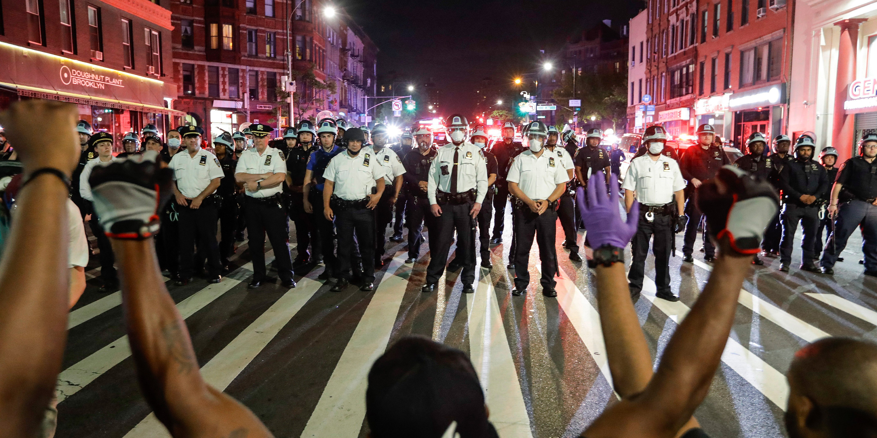 Protesters take a knee on Flatbush Avenue in front of New York City police officers during a solidarity rally for George Floyd