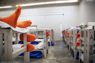 A detainee lays on a bunk in a pod at the Stewart Detention Center in Lumpkin, Ga. As of November 2019, 1,625 male detainees were said to be held at the center by ICE.