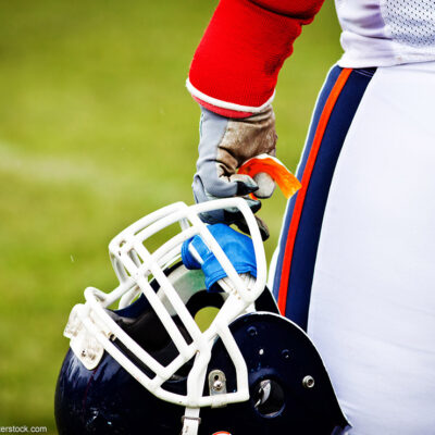 A football helmet in a player's hand.