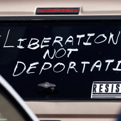 A car windshield with the hashtag "liberation not deportation" painted on it