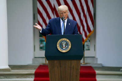 President Donald Trump speaks about podium with presidential seal during an event in the Rose Garden of the White House.