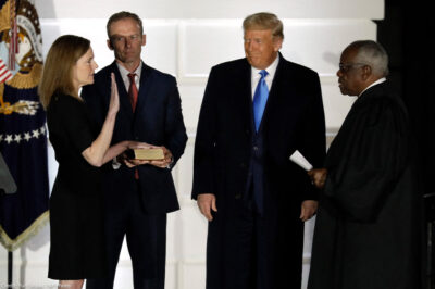 U.S. President Donald Trump smiles as Judge Amy Coney Barrett is sworn in as the Supreme Court associate justice by Justice Clarence Thomas on South Lawn of White House.