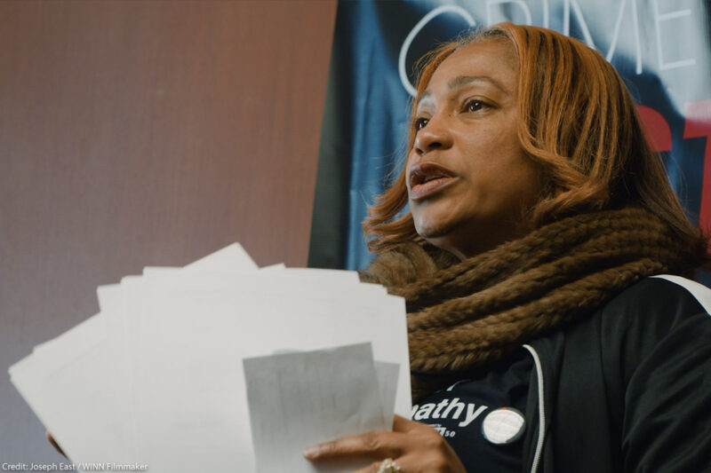 Pamela Winn holding papers in a still from the short film, WINN.