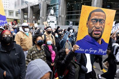 Demonstrators carry signs demanding justice for George Floyd.