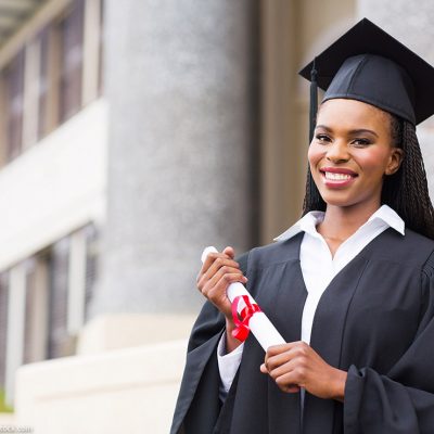 Black woman in cap and gown holds a diploma