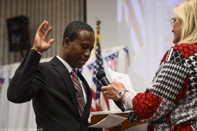 Mike Elliott takes the oath of office as the city's new mayor with city clerk Barb Suciu, right, during Elliot's inauguration ceremony