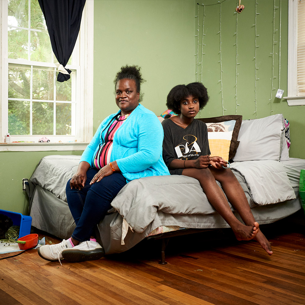 Mother and child sitting on a bed in a bedroom