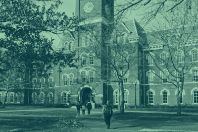 Green tinted picture of students walking on a college campus.