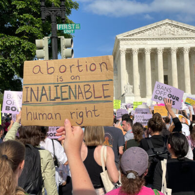 Protesters marching in Washington, DC, and carrying signs saying Abortion Is An Unalienable Human Right.