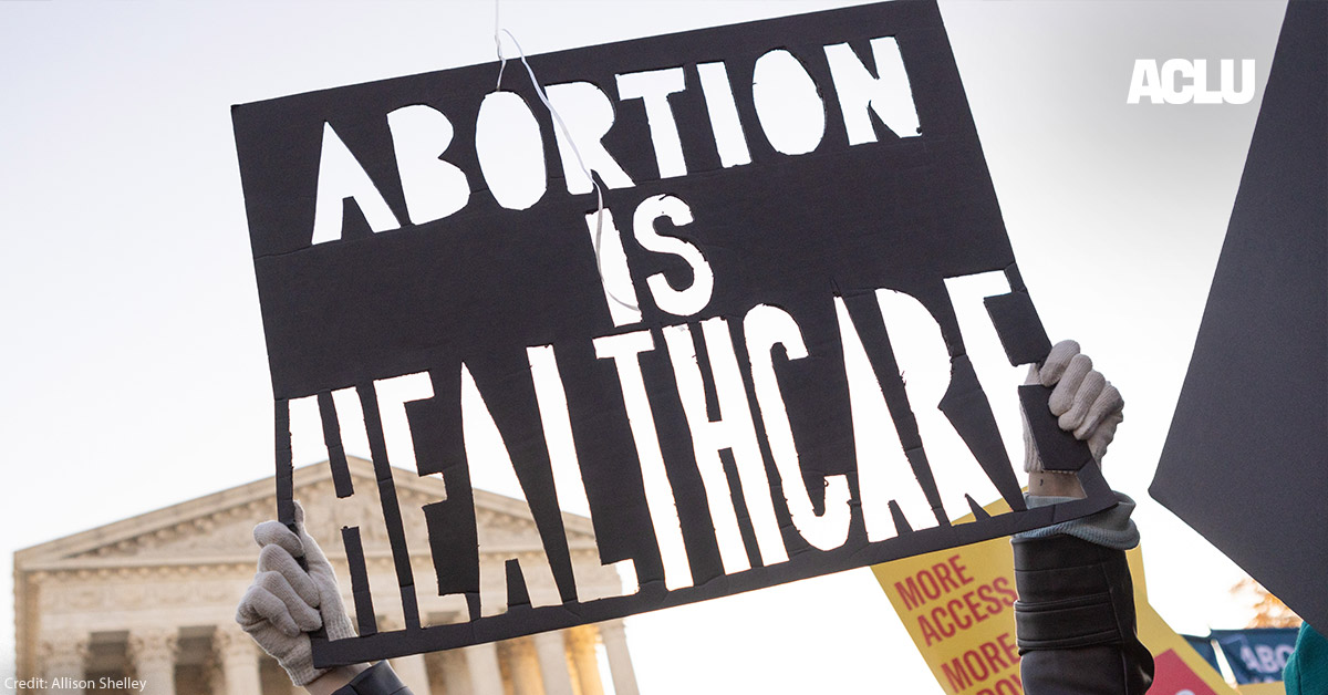 A person at a rally holding a sign that says “Abortion is Healthcare.”